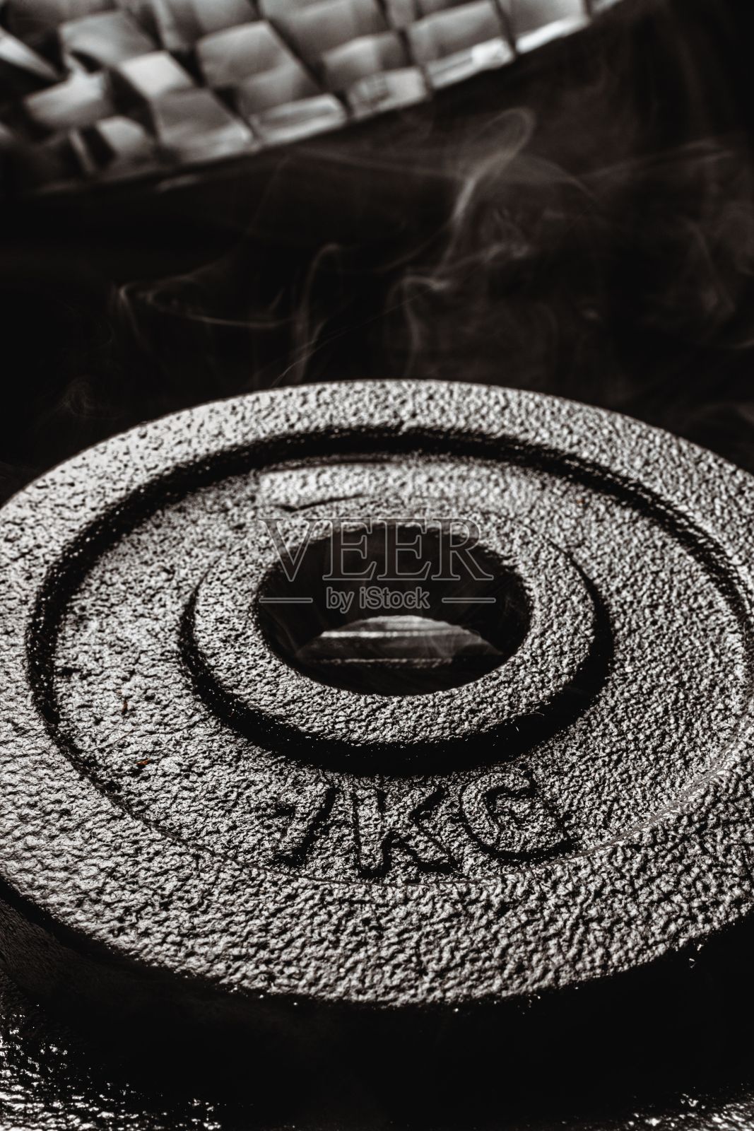 灰度垂直拍摄1kg哑铃重量板。照片摄影图片