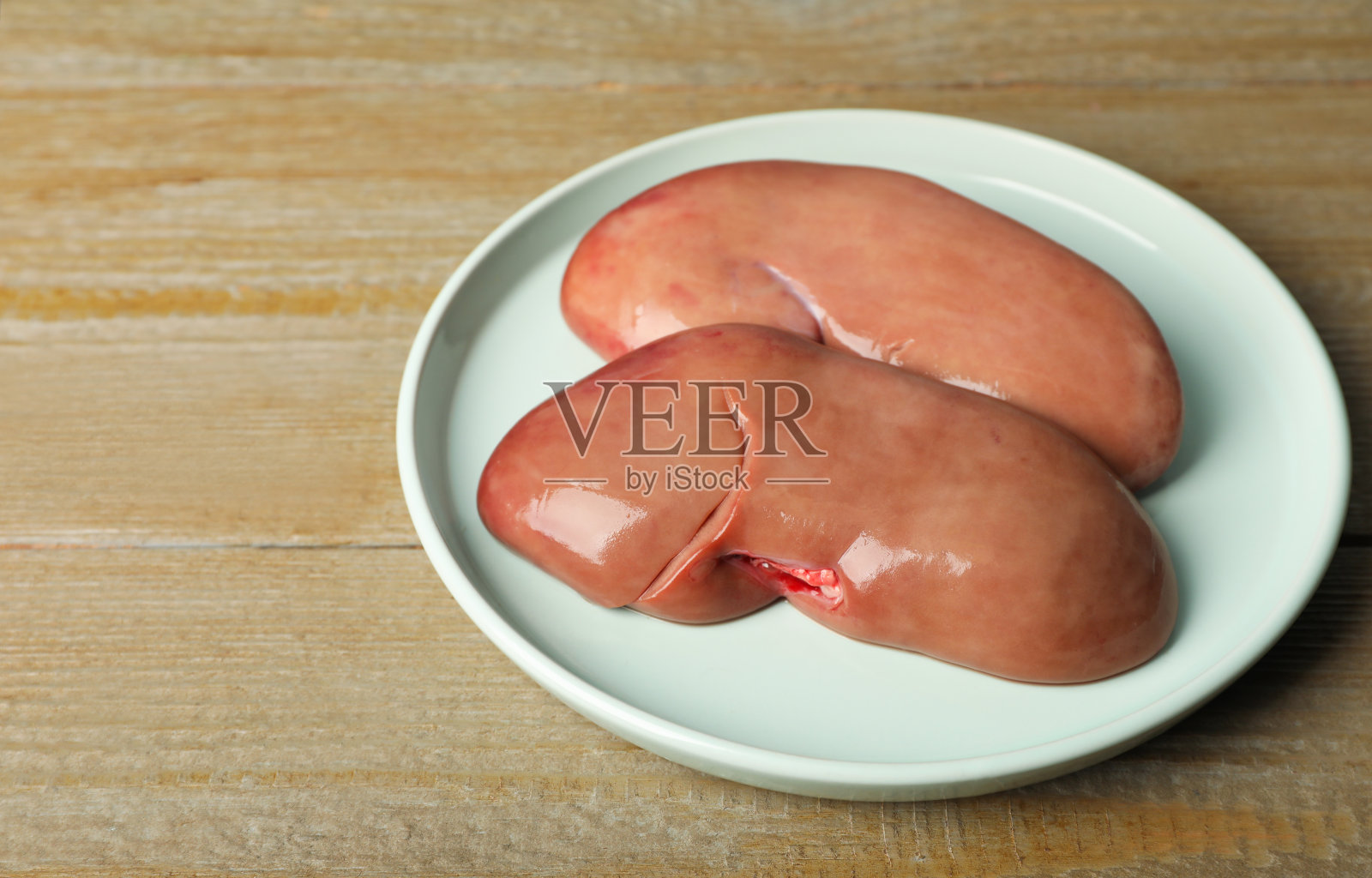 木桌上放新鲜的生猪腰子照片摄影图片