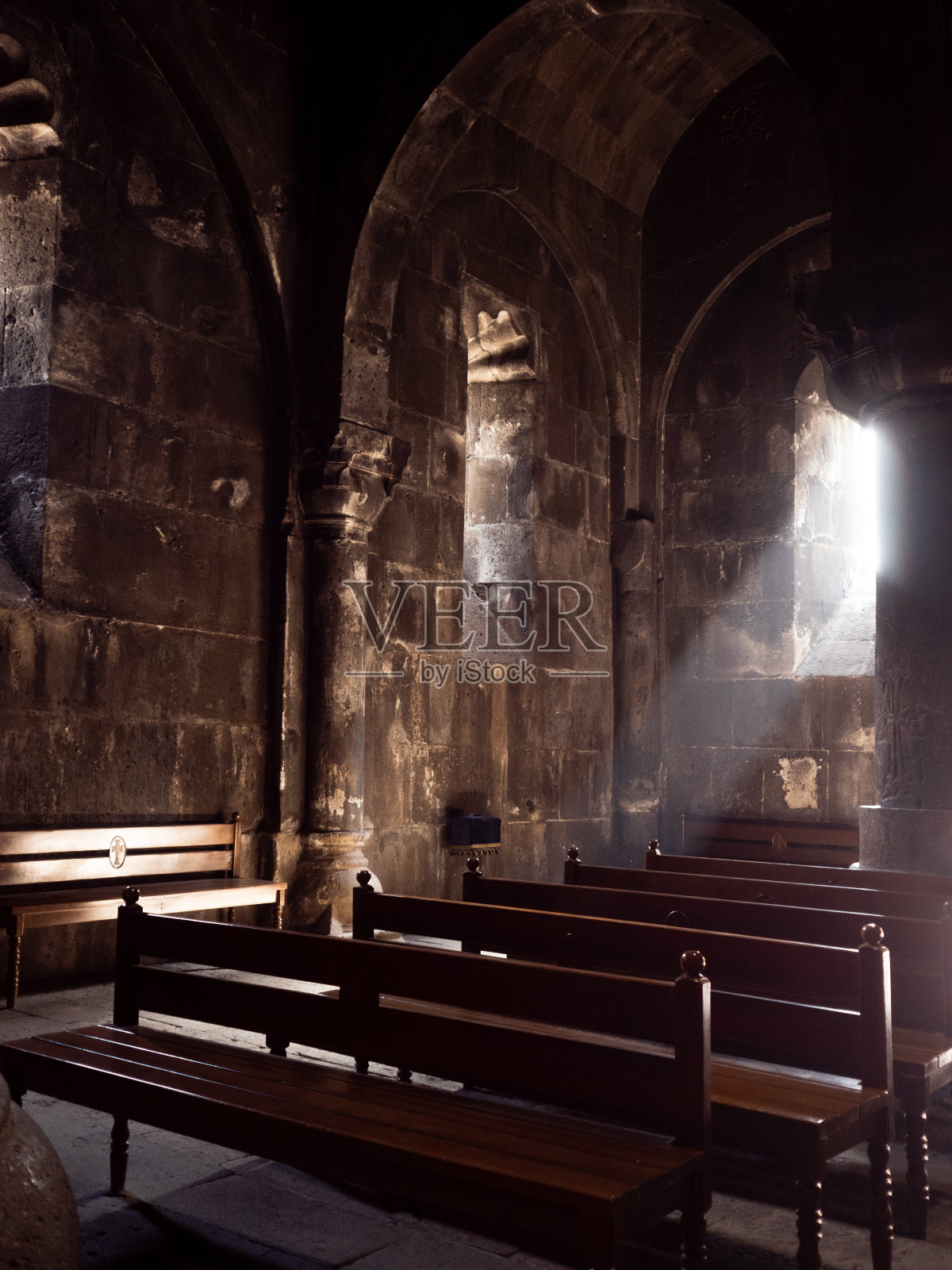 古老教堂内的长椅沐浴在神圣的光芒中，用于祈祷照片摄影图片