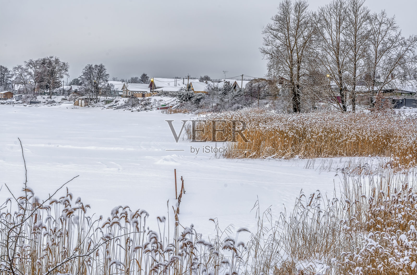 冬天里水库岸边的房子。照片摄影图片