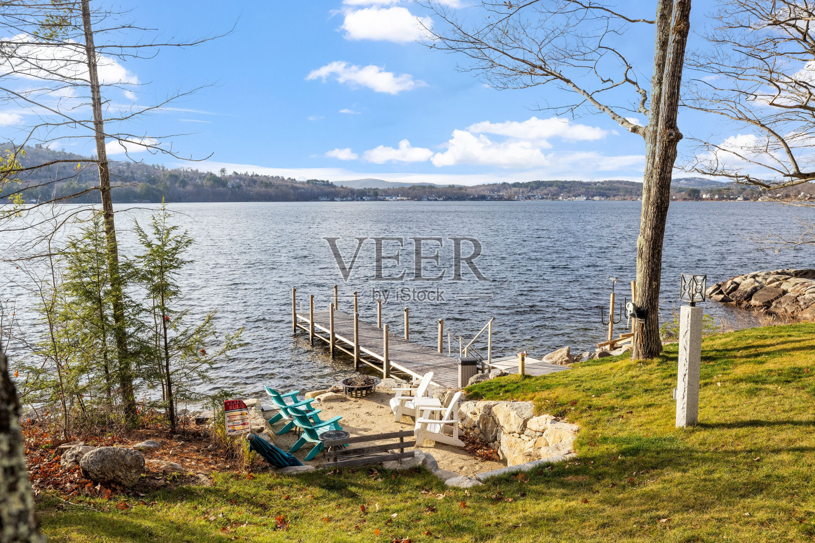 阳光明媚的一天，美丽的码头和湖岸的椅子照片摄影图片