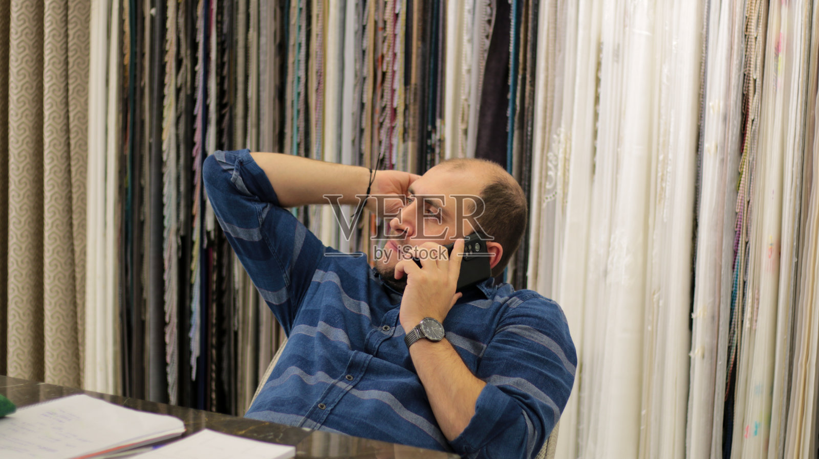 穿着蓝色衬衫的彩色眼睛男人在打电话照片摄影图片