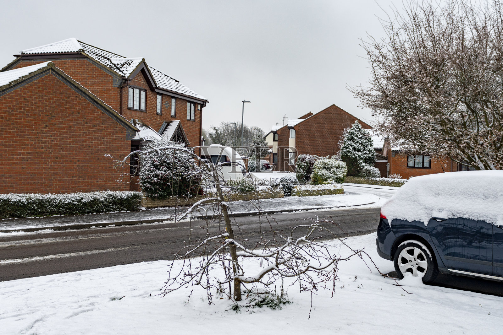 剑桥郡亨廷顿的斯图克雷草甸庄园，房屋和汽车的屋顶上有雪照片摄影图片
