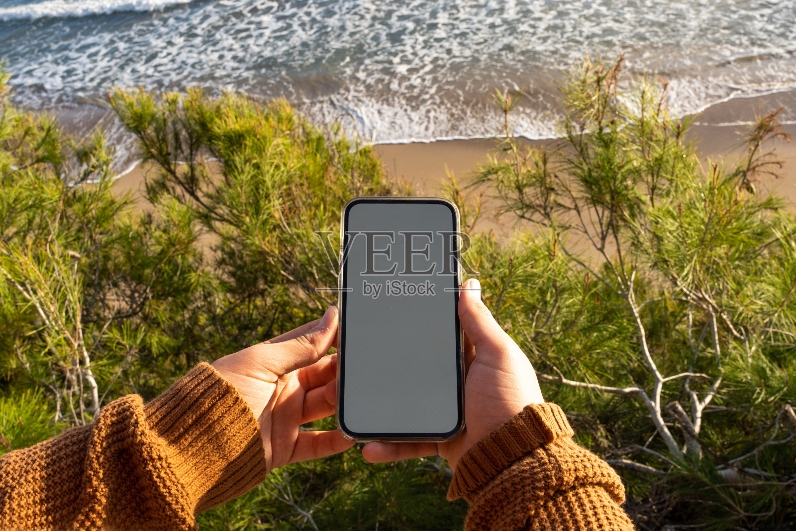 在海滩上使用智能手机的孩子照片摄影图片