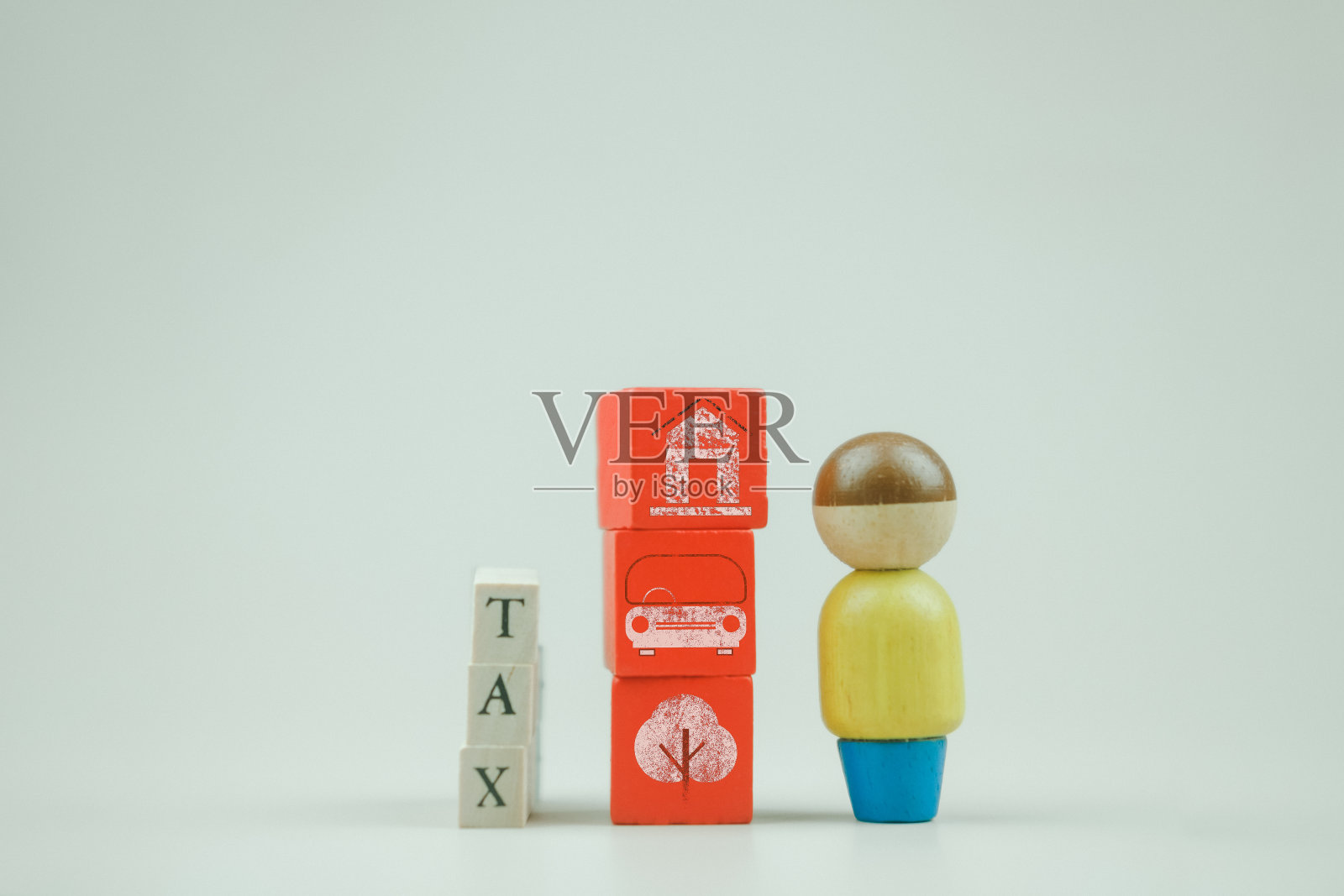税务文本写在木块上，旁边是木头人的家，汽车和环境的图标。照片摄影图片