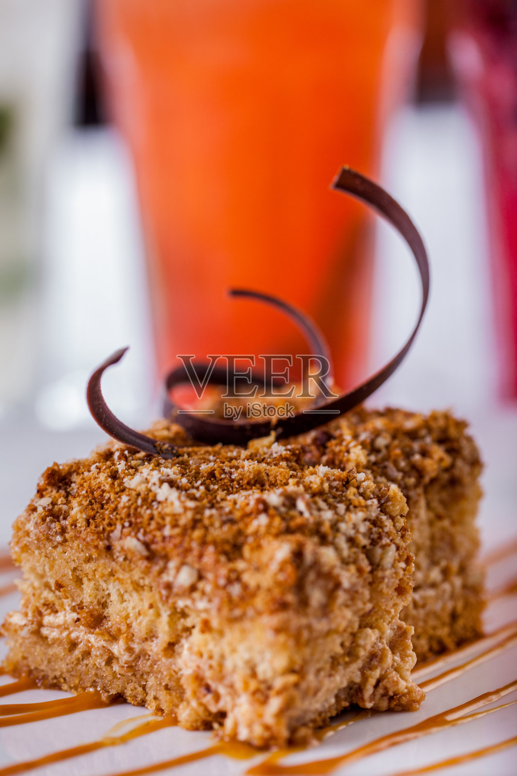 一块拿破仑蛋糕，巧克力片和焦糖放在一个白色的盘子特写。垂直方向照片摄影图片