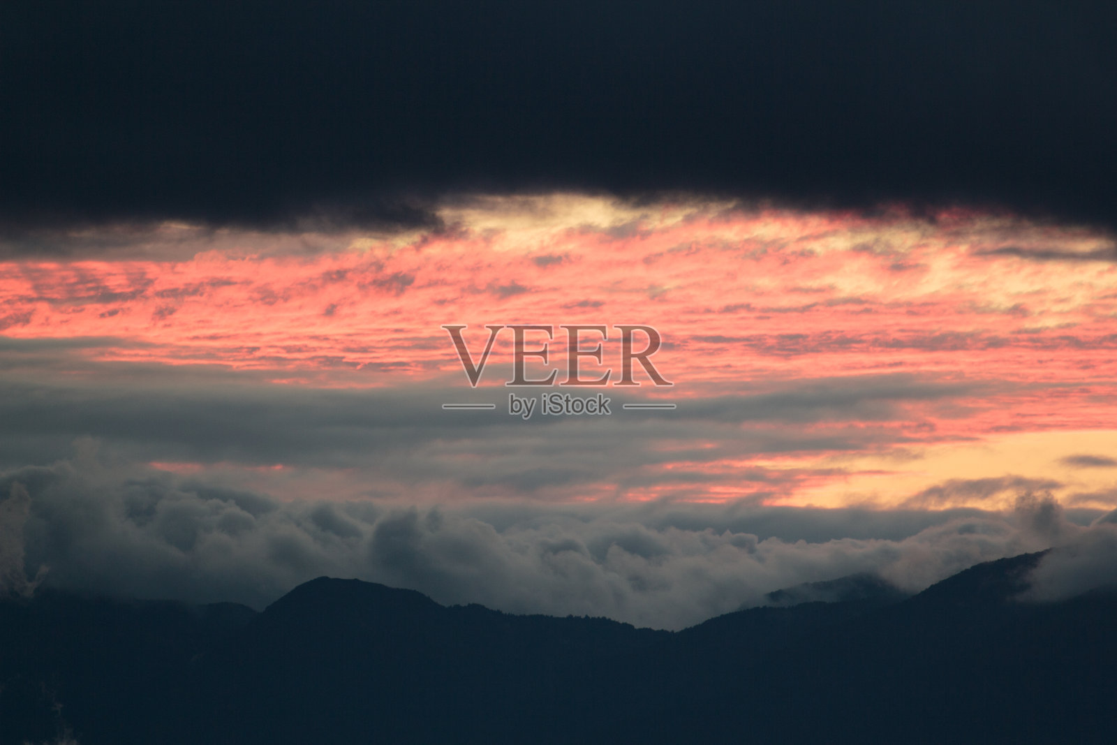 近距离的云和火红的日落在山上照片摄影图片