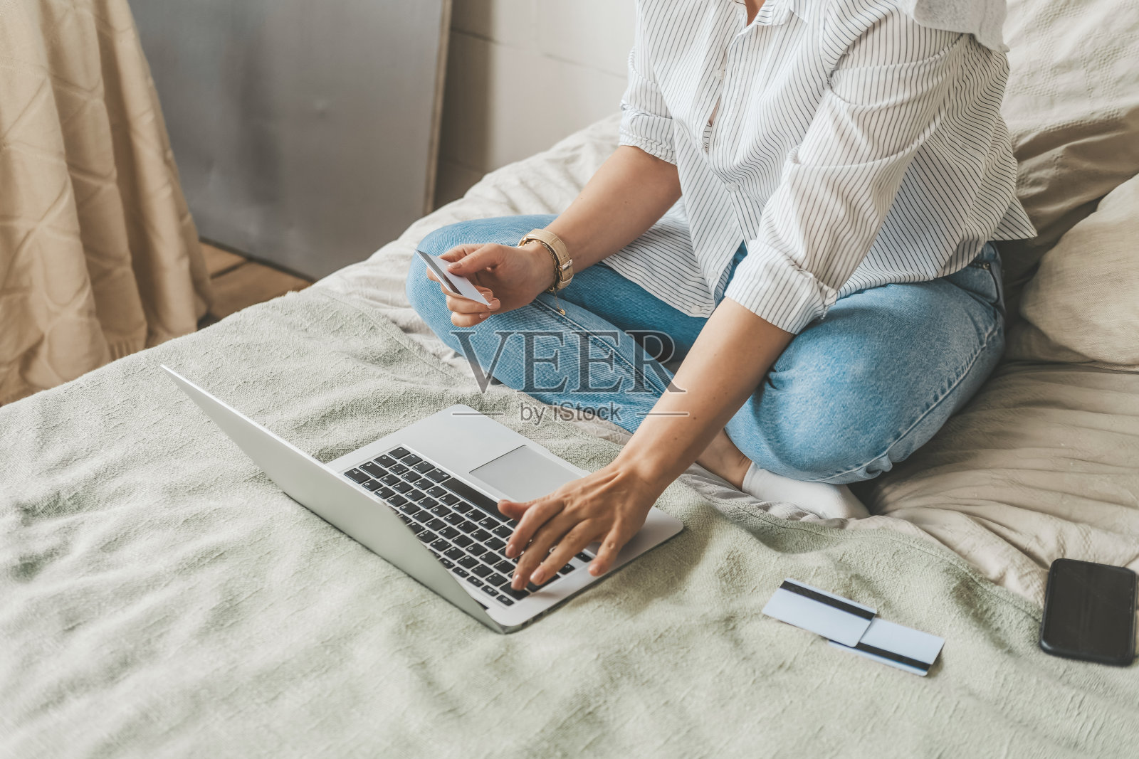 在家躺在床上的女人在网上购物。黑色星期五大减价的乐趣。照片摄影图片