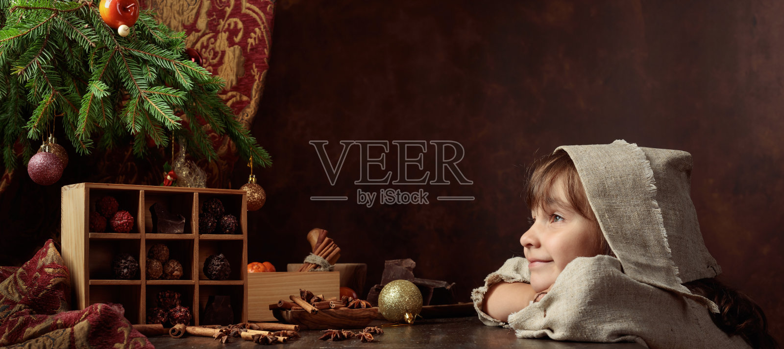 小女孩和巧克力在圣诞树下。照片摄影图片