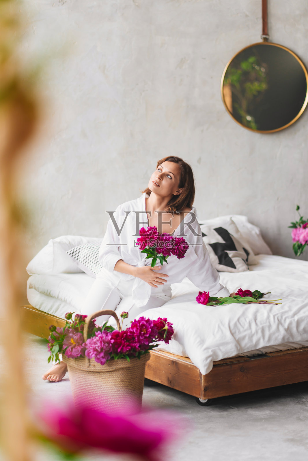 卧室里有个穿着白衣、戴着牡丹的漂亮女人。家里舒适。照片摄影图片