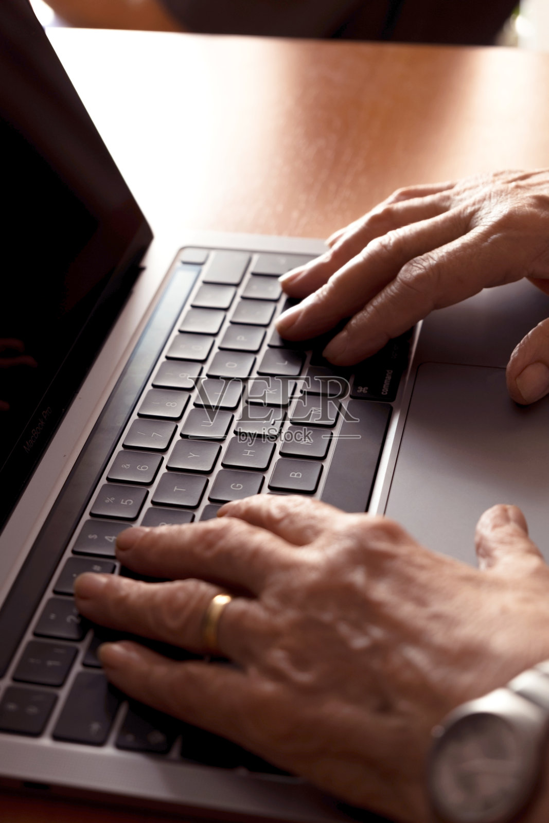 一位老人在笔记本电脑上的手的垂直图像照片摄影图片