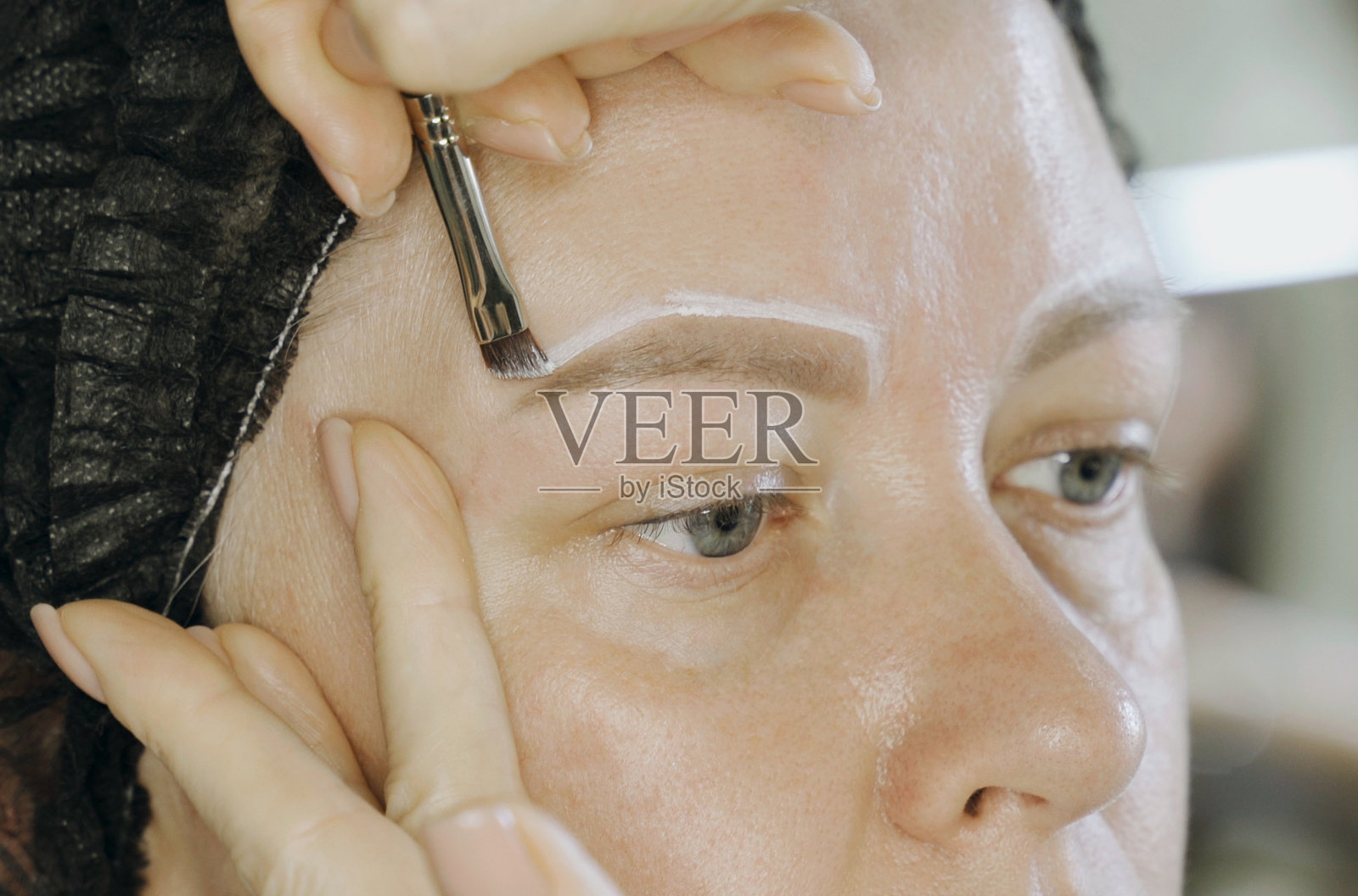 用眉毛形状的白色线条在脸上着色。照片摄影图片