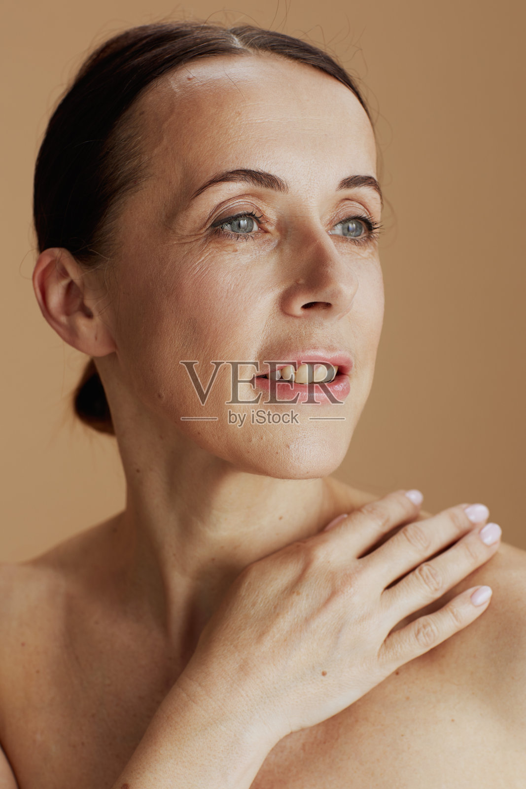 现代女性在米色背景上孤立地摆姿势照片摄影图片