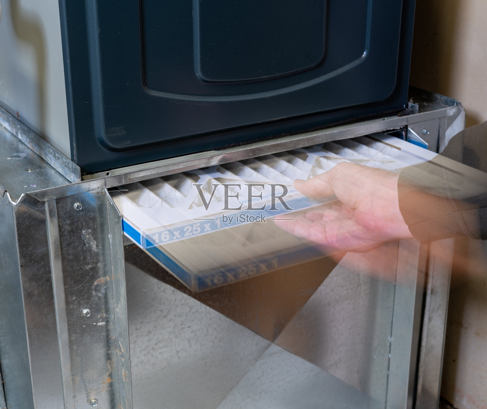 男子更换家中肮脏的炉过滤器照片摄影图片