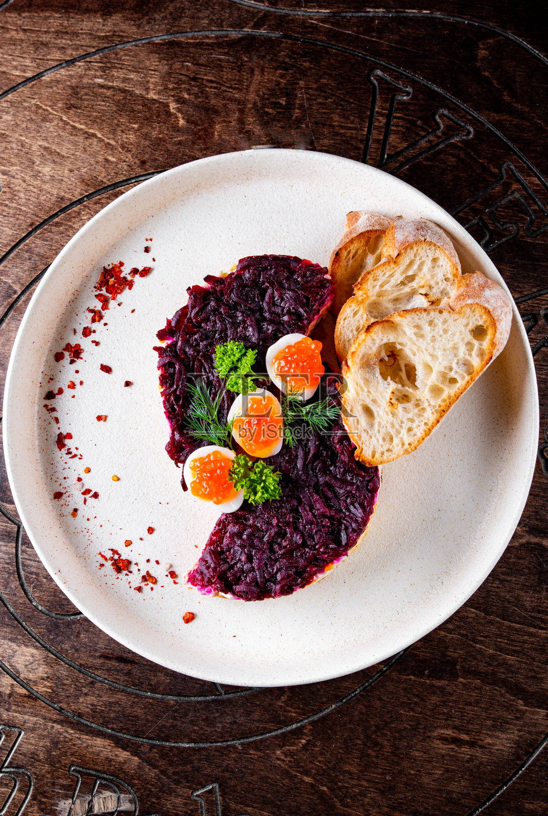 盘子里有三文鱼、甜菜、胡萝卜、洋葱、土豆和鸡蛋的分层沙拉。照片摄影图片