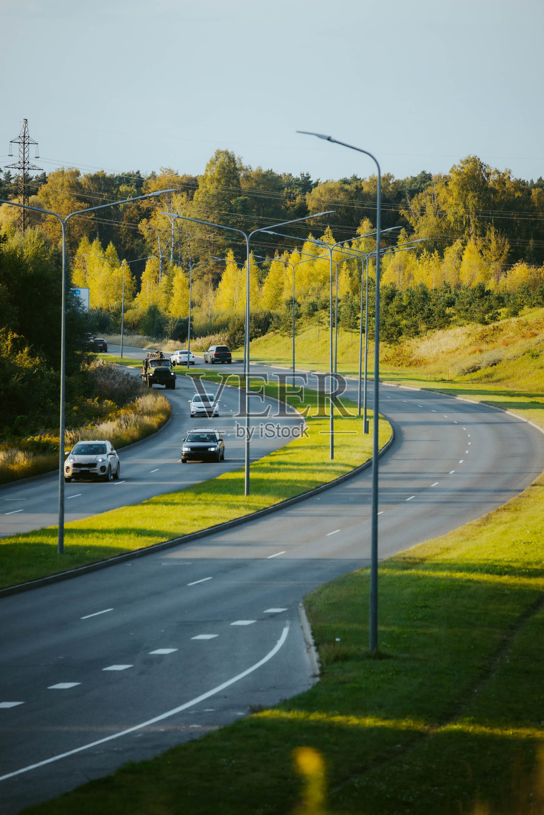 在晴朗的蓝天下，沿着高速公路行驶的汽车的垂直俯视图照片摄影图片