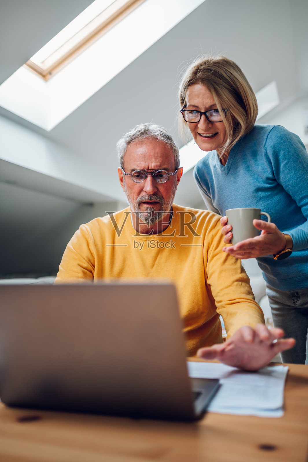一对中年夫妇在家里一起使用笔记本电脑照片摄影图片