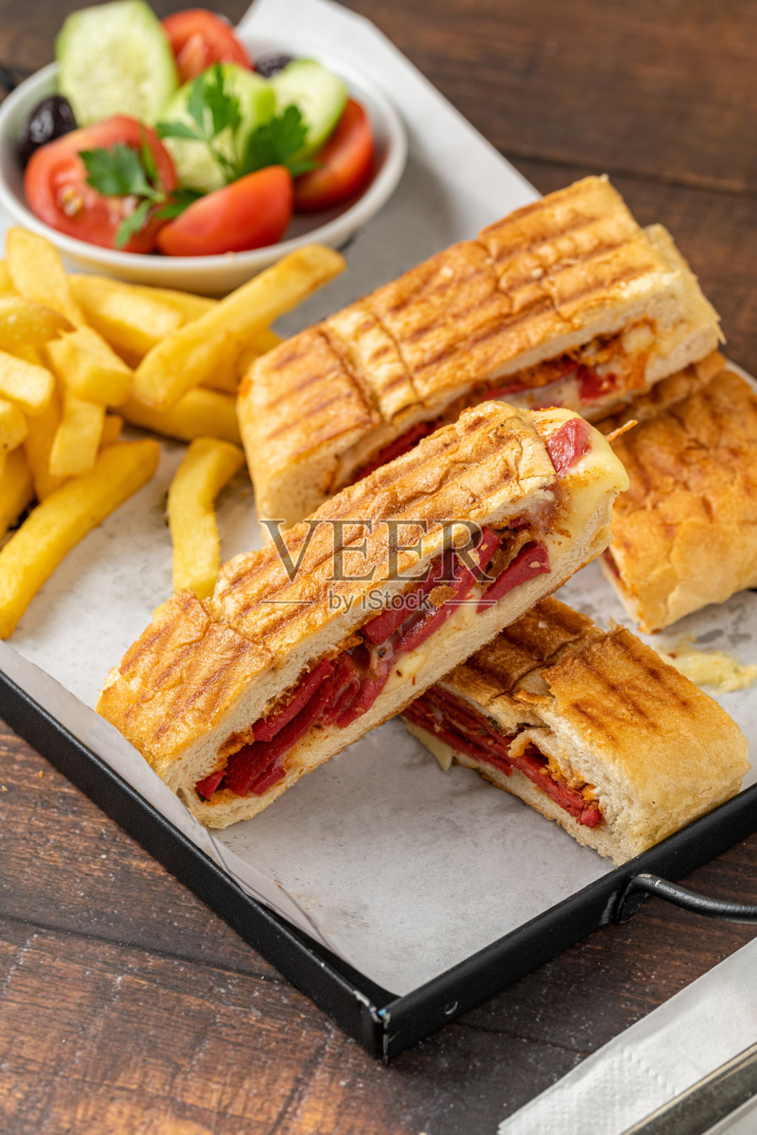 吐司、切达干酪、土耳其香肠、薯条和沙拉放在木桌上照片摄影图片