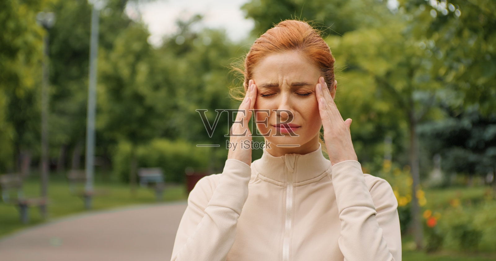 女性慢跑时头痛。照片摄影图片
