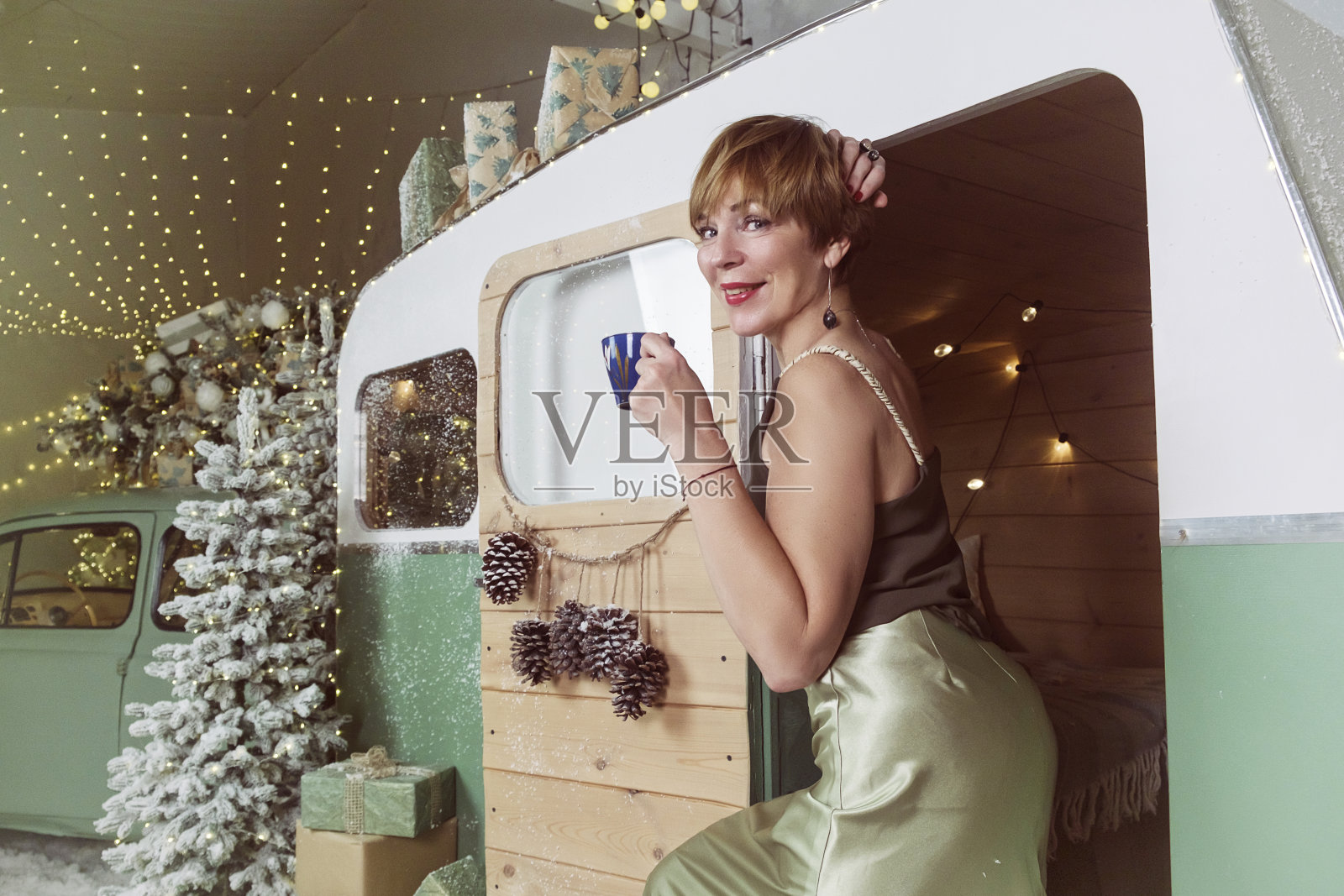 一名成年女子在新年来到冰场，坐在圣诞树旁的长椅上喝咖啡照片摄影图片