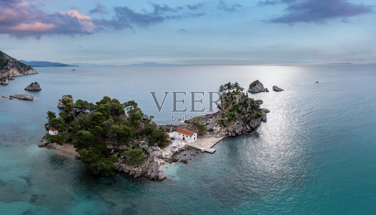 希腊Parga。无人机鸟瞰帕纳吉亚岛，小教堂和岩石上的树木照片摄影图片