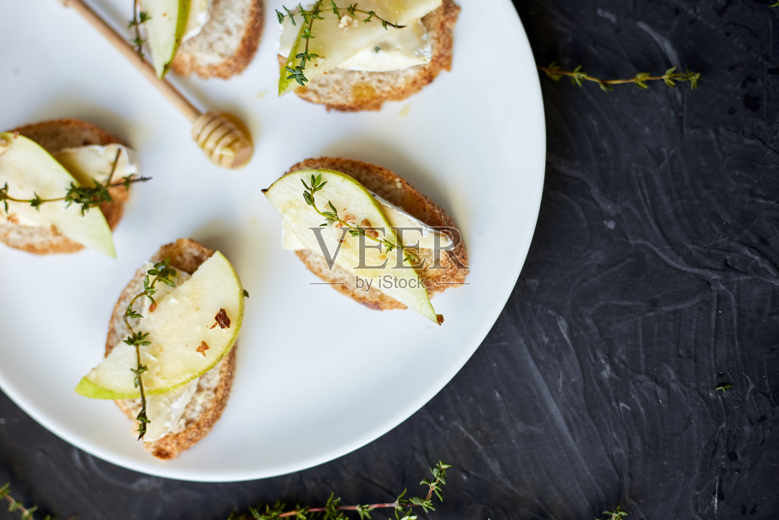 白盘子上的三明治或意式烤面包配梨和蓝奶酪照片摄影图片