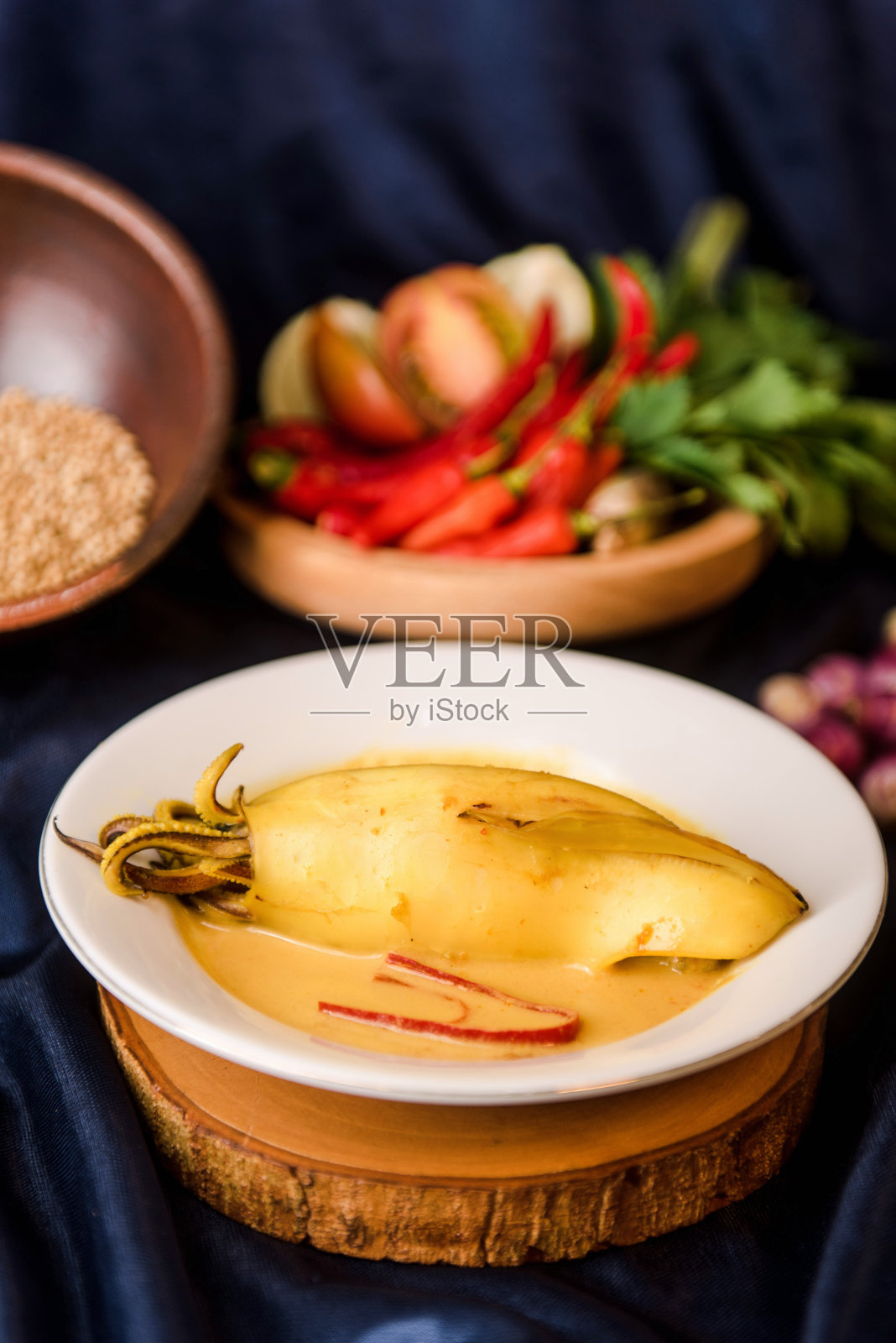 古来鱿鱼或用黄色调味的椰奶煮熟。印尼食品照片摄影图片