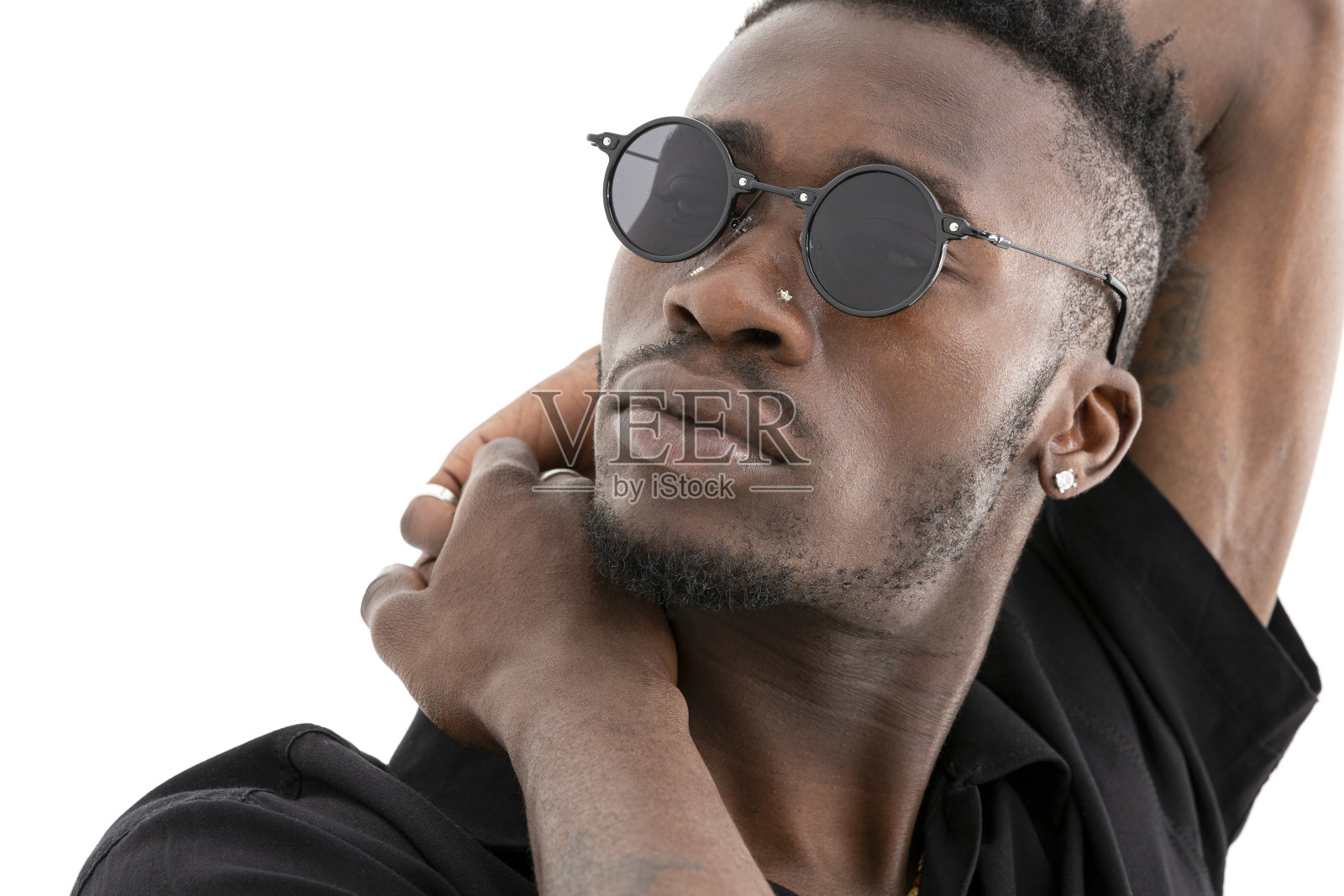 一个非洲裔美国人，穿着黑色衬衫，戴着太阳镜，背景是白色的。照片摄影图片