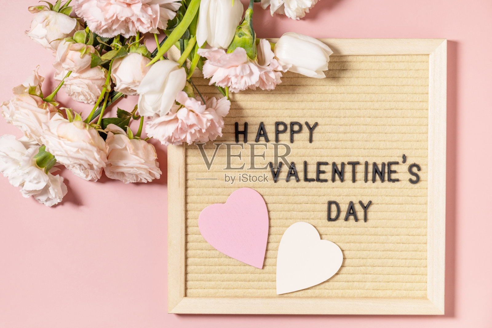 情人节快乐的字母在信板和美丽的春天花朵在浅粉色的背景。情人节，妇女节，母亲节贺卡。从上面看。照片摄影图片