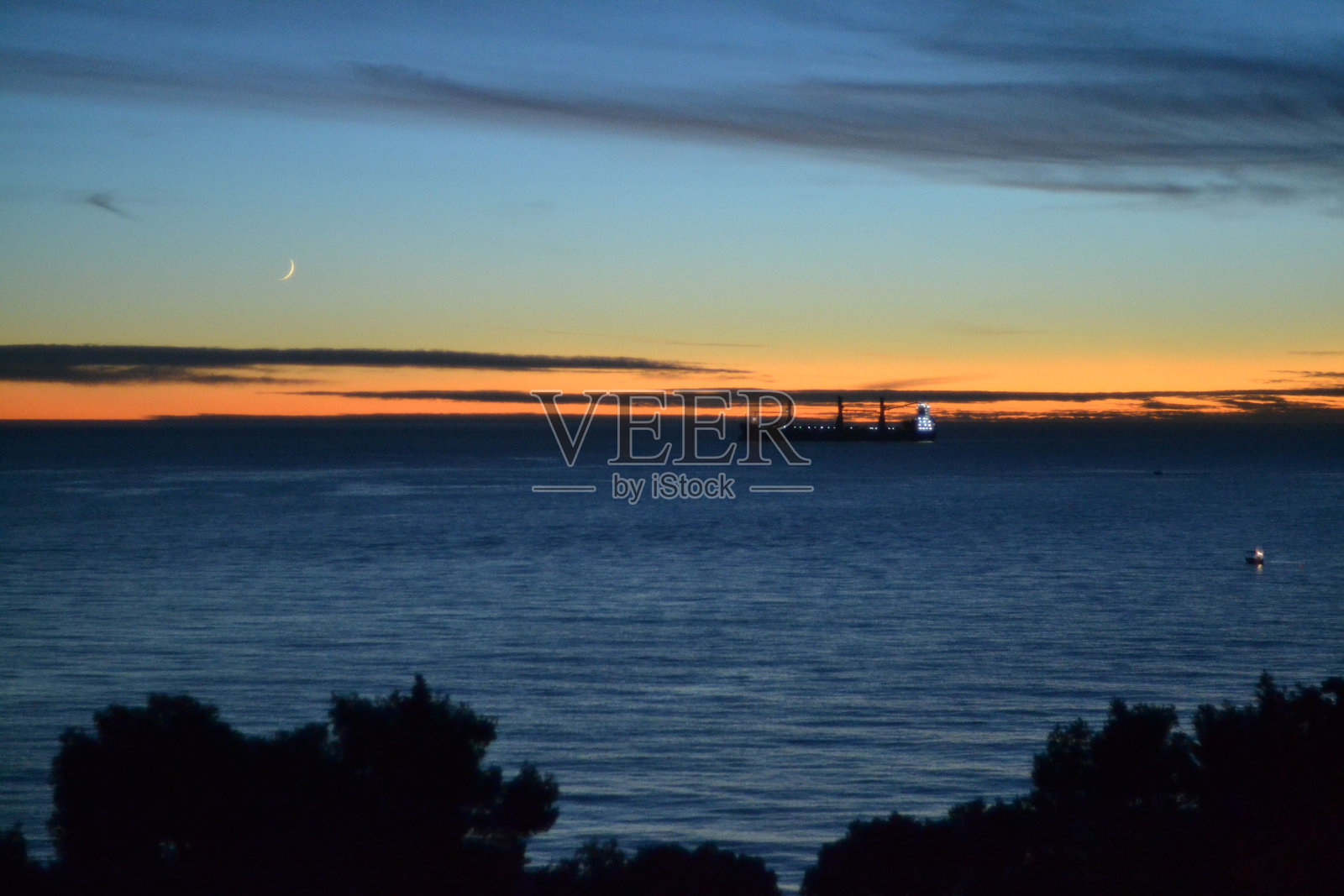夕阳在平静的海浪上的田园诗般的景色照片摄影图片