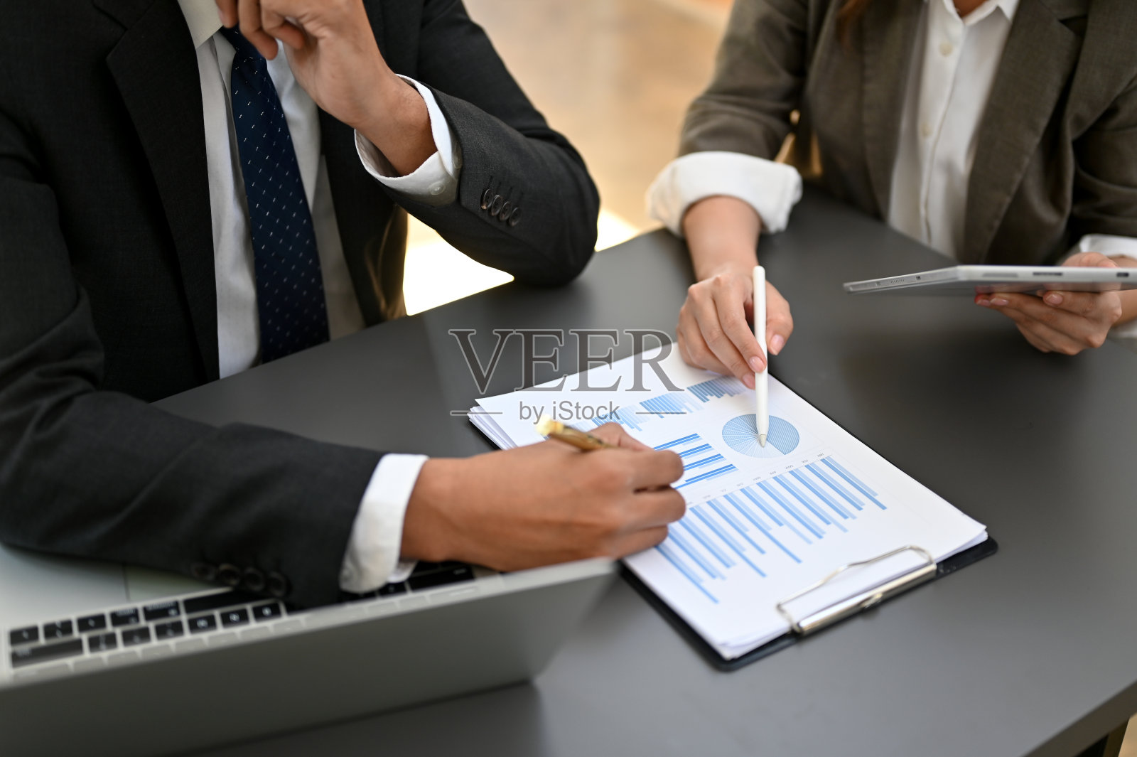 专业的亚洲商人和一位女会计一起工作，笔尖指着纸。俯视图照片摄影图片