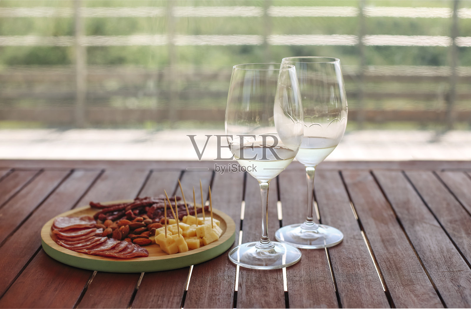 午餐有新鲜的开胃菜和白葡萄酒供应在绿色草地的户外照片摄影图片