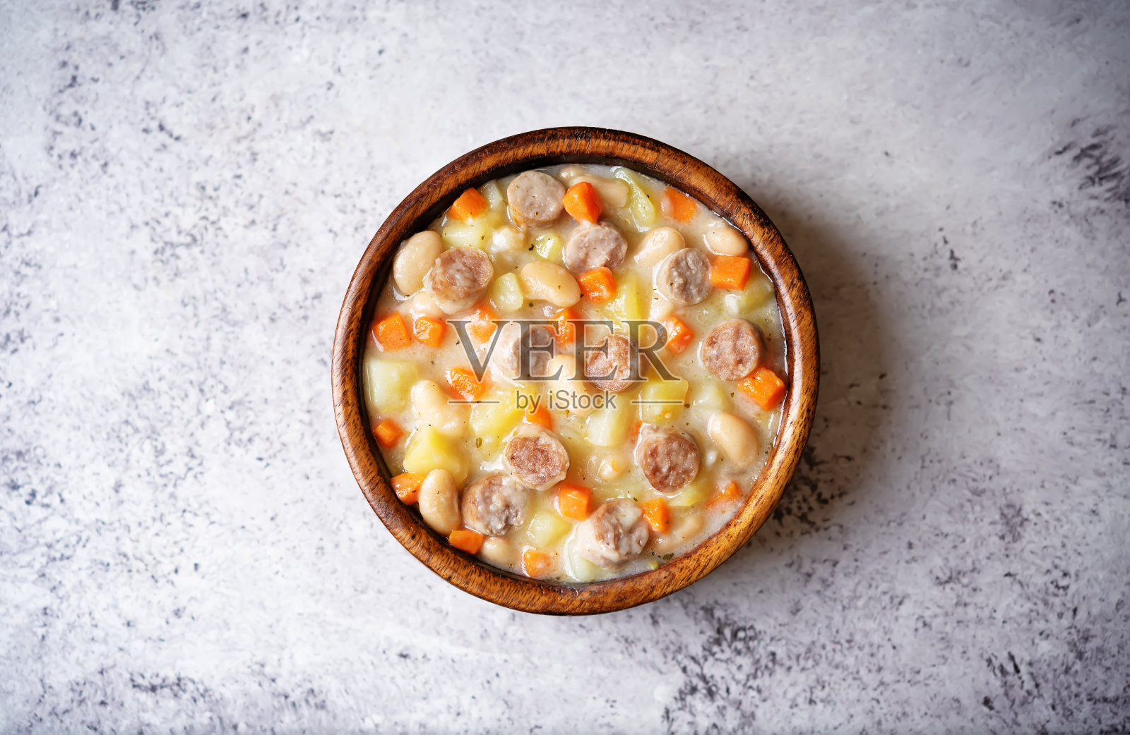 土豆胡萝卜白豆汤配肉肠碗照片摄影图片