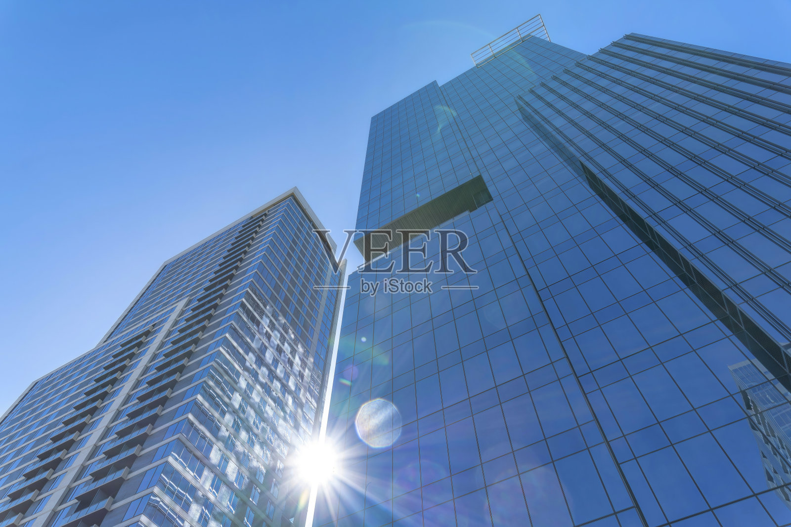 现代玻璃住宅在阳光和蓝天的映衬下高耸入云照片摄影图片