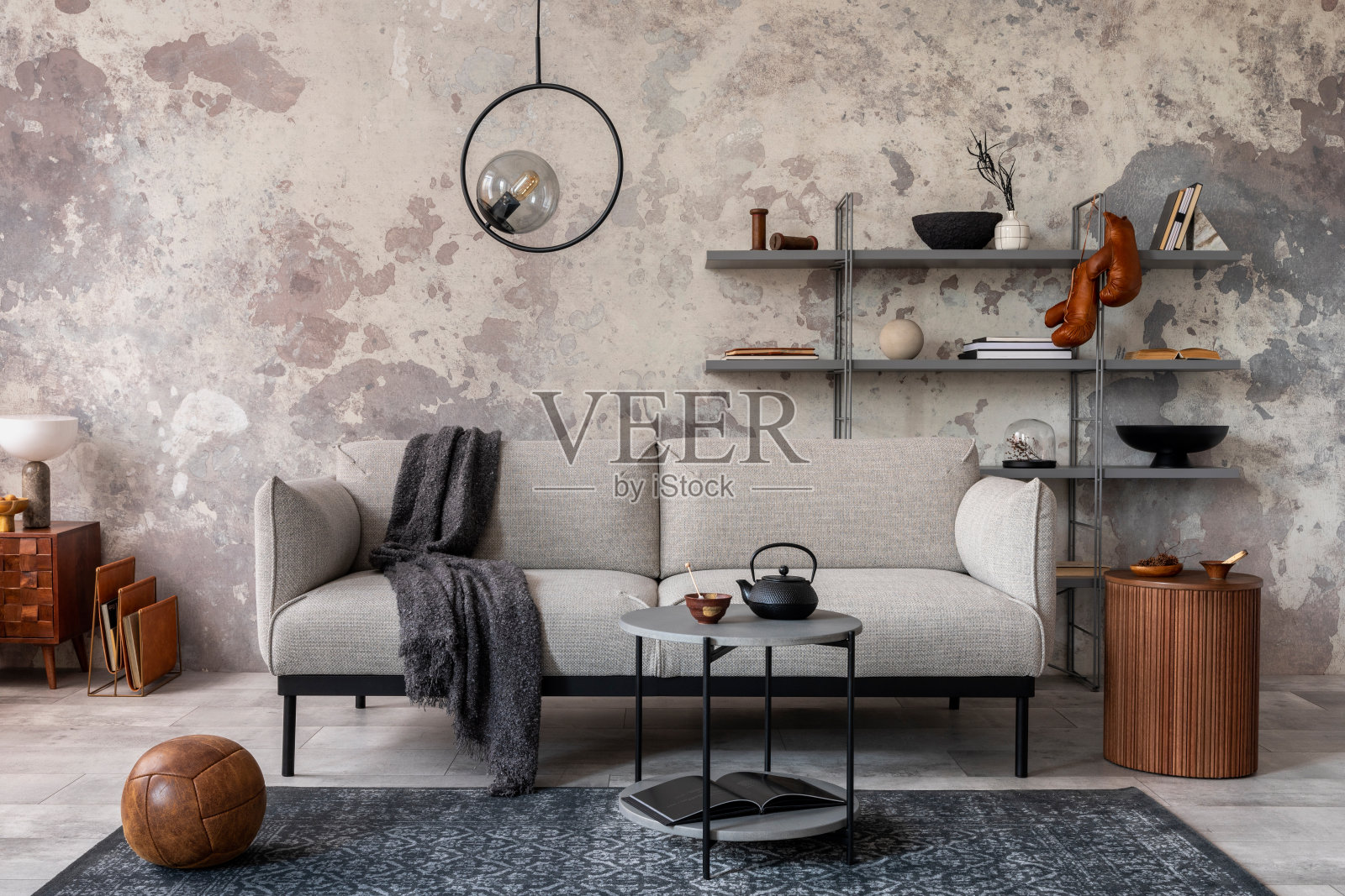 阁楼风格的现代公寓，灰色设计的沙发，大理石咖啡桌，书柜，迂腐的灯，地毯，装饰和优雅的配件。混凝土垃圾墙。模板。照片摄影图片