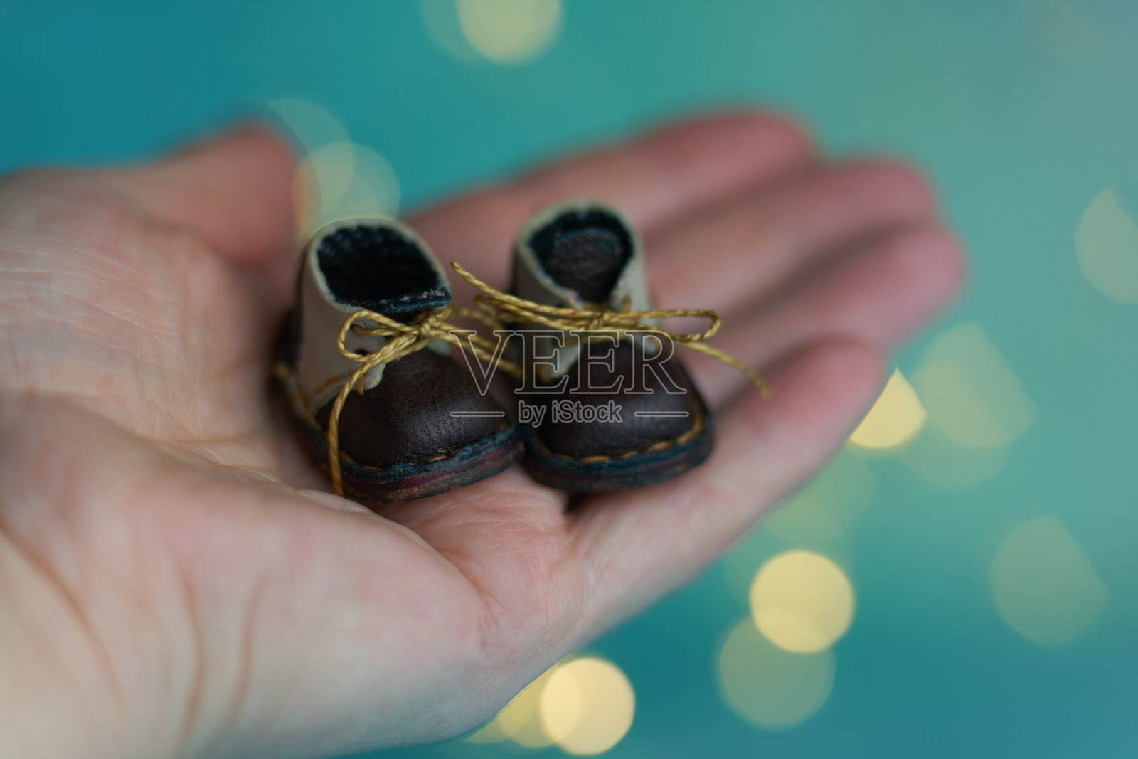 可爱的小靴子的泰迪熊或玩偶在圣诞光的背景。节日光辉的背景。背景与闪烁的光散焦。模糊的散景。照片摄影图片