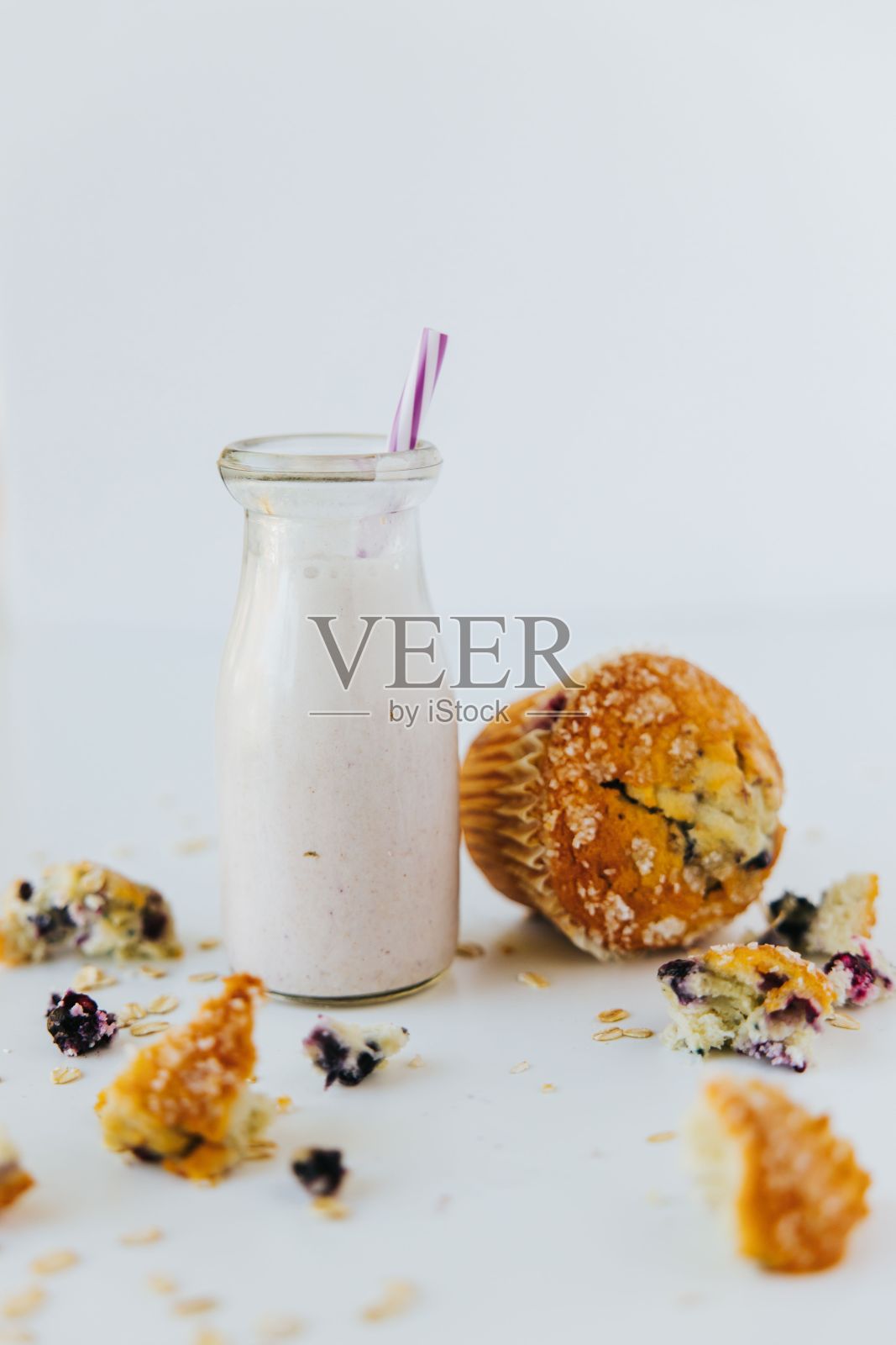 垂直特写镜头是一杯蛋白质奶昔，旁边有一块松饼照片摄影图片