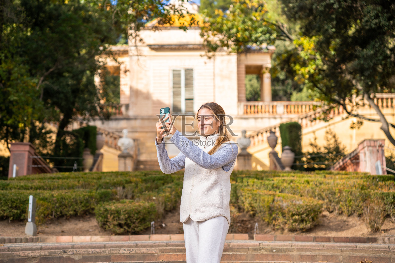 一个女孩用她的手机拍照。照片摄影图片