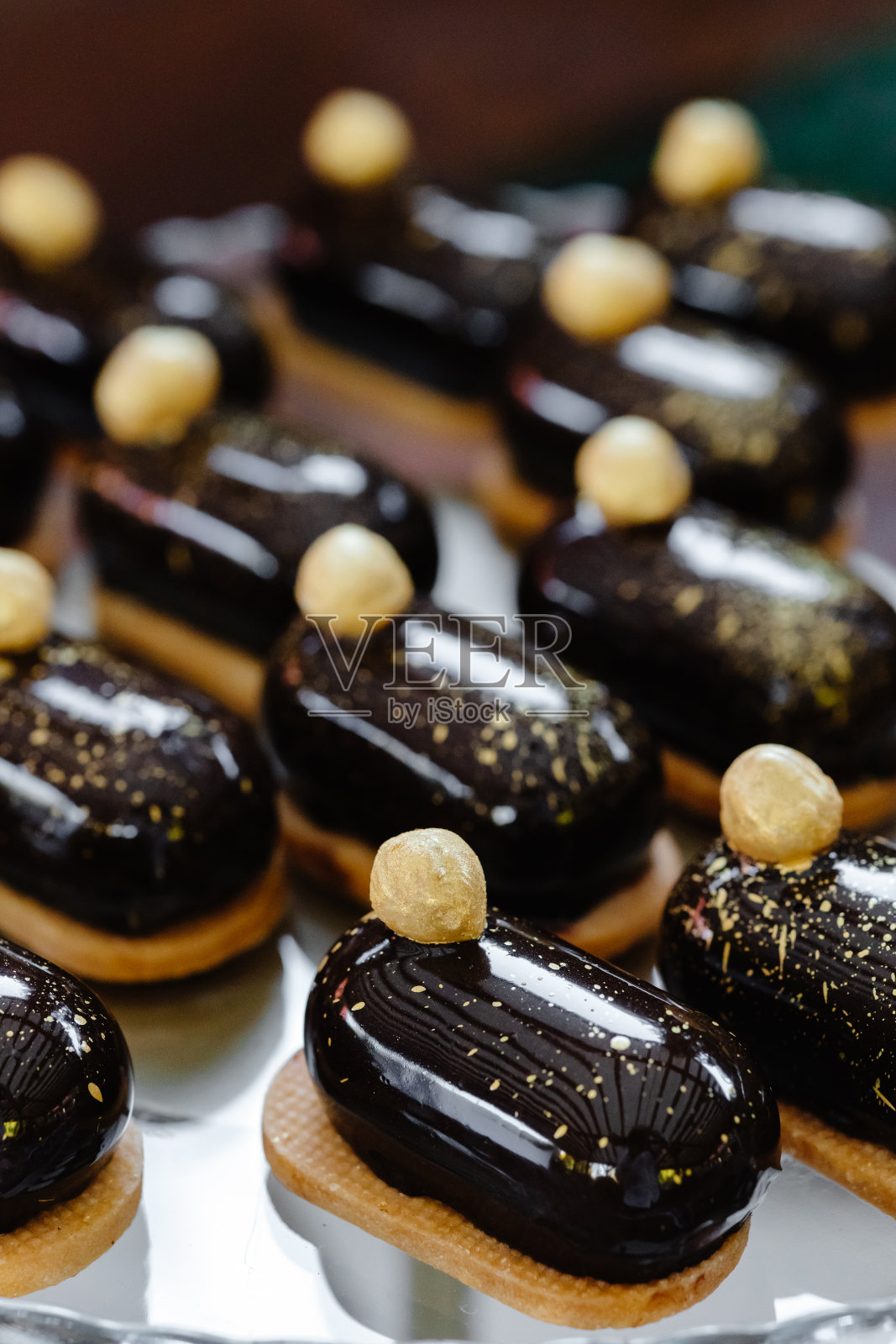 各式各样的巧克力泡芙和坚果放在节日的餐桌上照片摄影图片