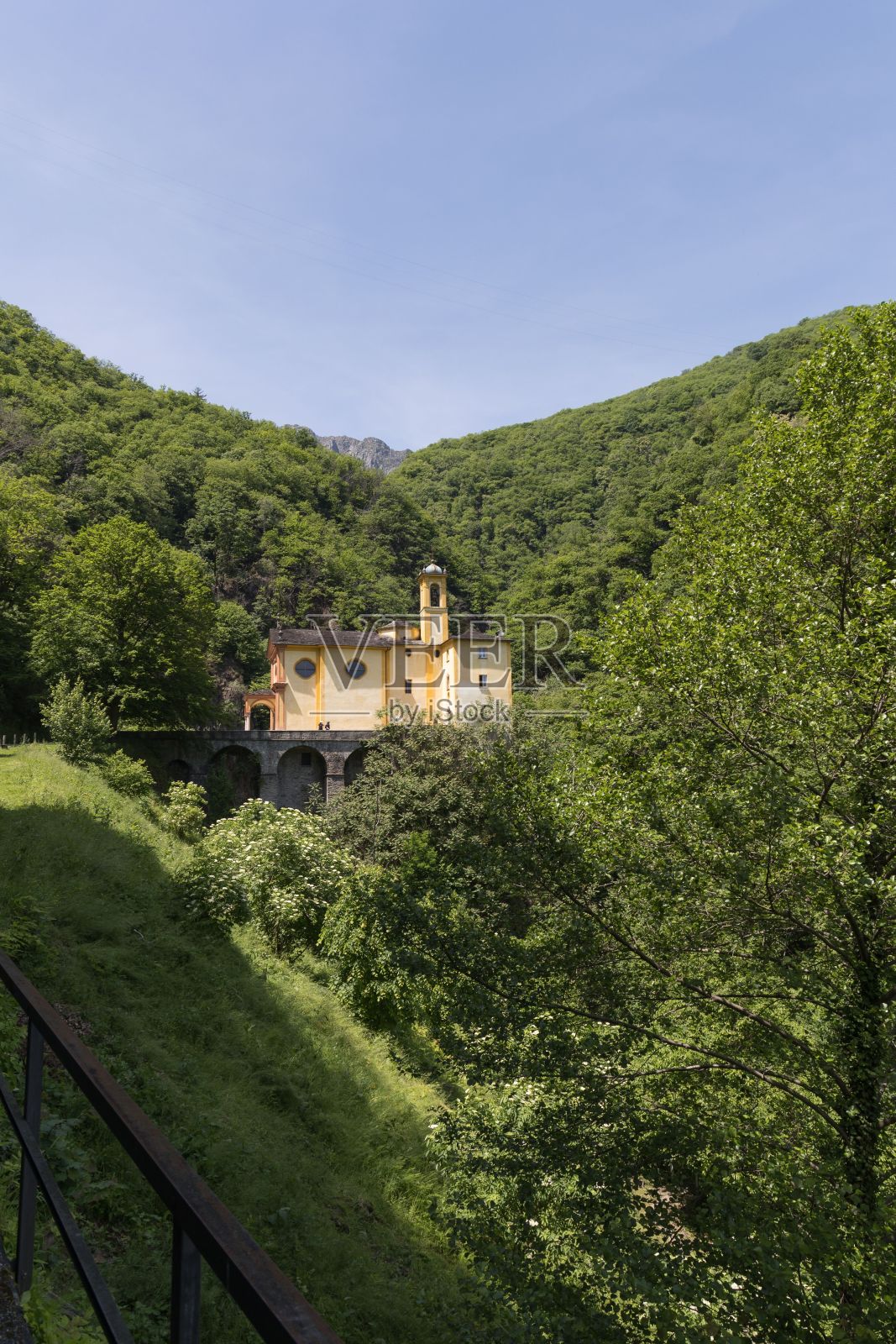 瑞士布里萨戈的圣玛丽亚·阿多罗拉塔教堂与森林的垂直视图照片摄影图片