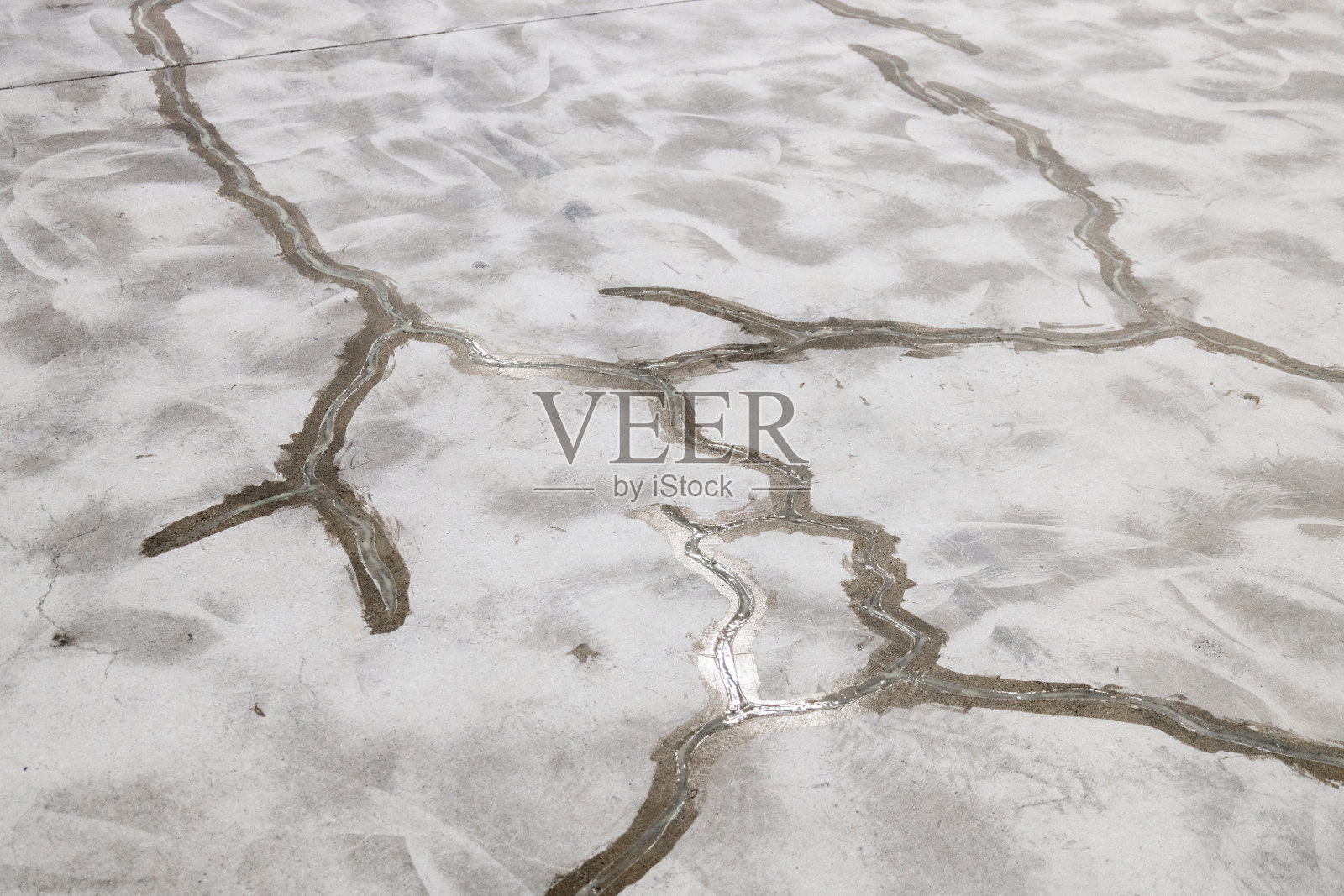 水泥地面上有许多裂缝，某工业建筑水泥地面上的修复照片摄影图片