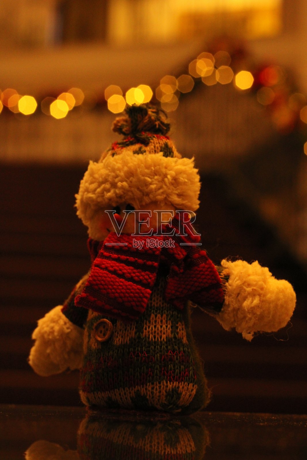 专注于雪人装饰。背景中模糊的灯光和楼梯照片摄影图片