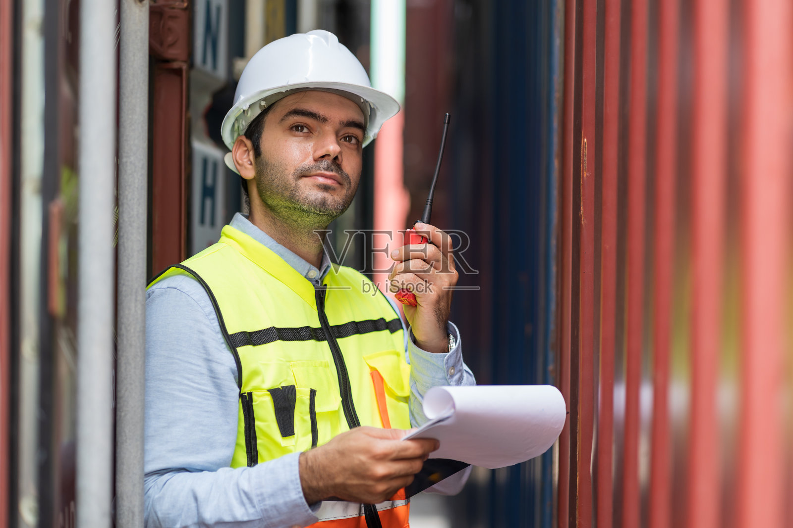 男性集装箱堆场工程师在控制装车前修理或维护集装箱箱。领班或主管工作，检查从货轮运来的集装箱箱内的产品照片摄影图片