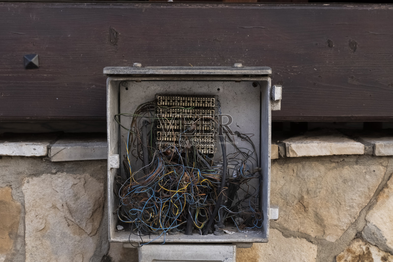 连接在未完工建筑混凝土底座上的电力分配器，旁边是大型电缆。一栋未完工的高层建筑的电费账单。照片摄影图片