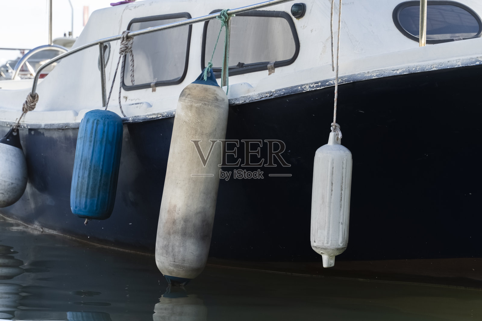 船首的旧船与剥落的油漆，漂浮在水面上的码头，游泳在波浪上，侧视图，近距离。照片摄影图片