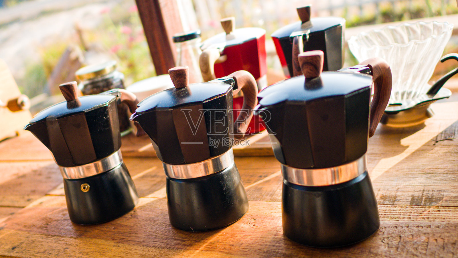 在咖啡厅的木桌和咖啡杯上设置摩卡壶和旧咖啡机照片摄影图片