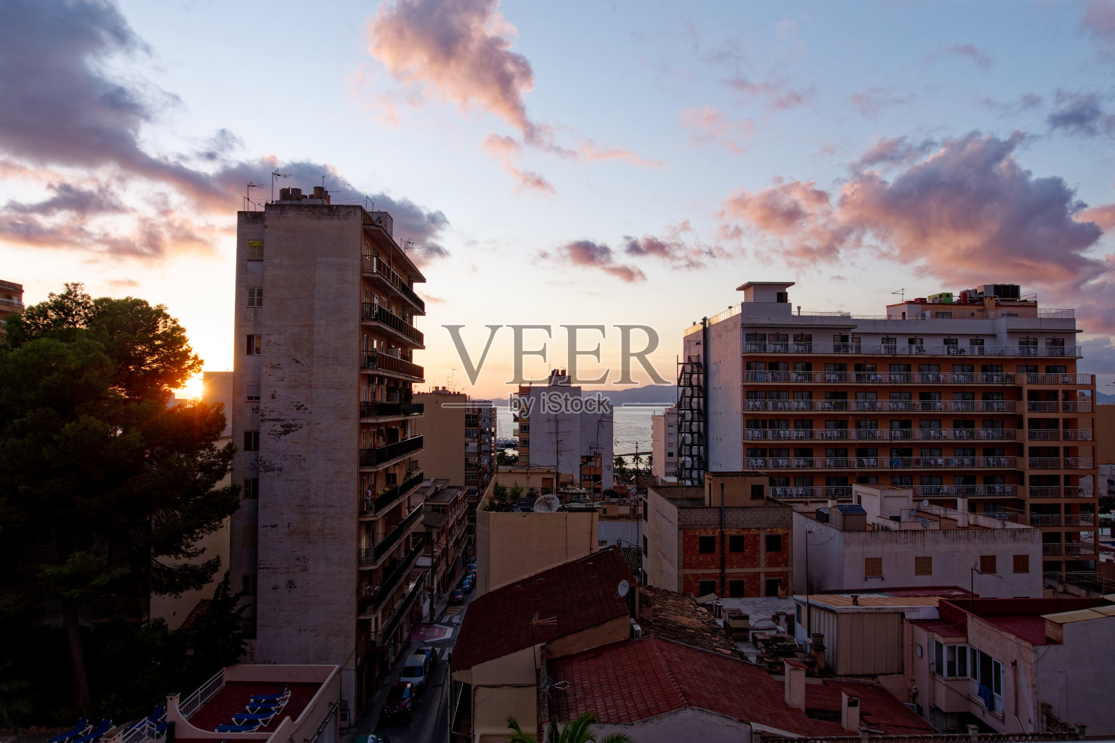 美丽的红色天空，红色的太阳，海洋，红色的云和公寓的轮廓在马略卡岛的一个秋天的晚上。照片摄影图片