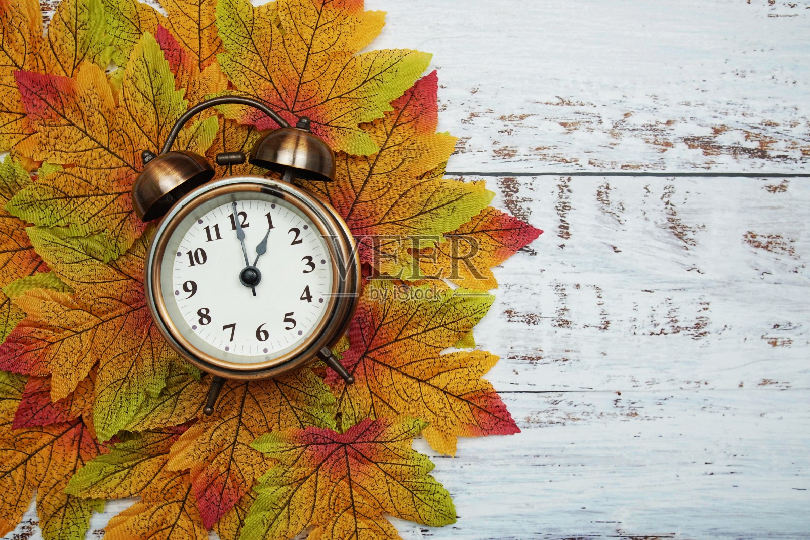 木制背景上的枫叶闹钟照片摄影图片