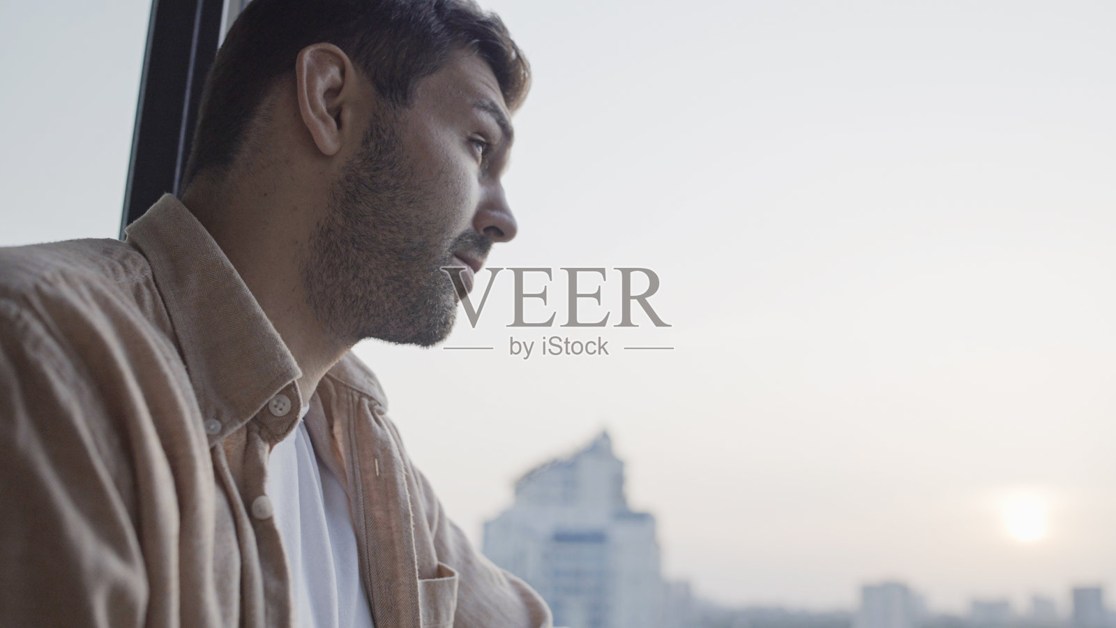 有思想的年轻人看着窗外，做着重要的决定照片摄影图片