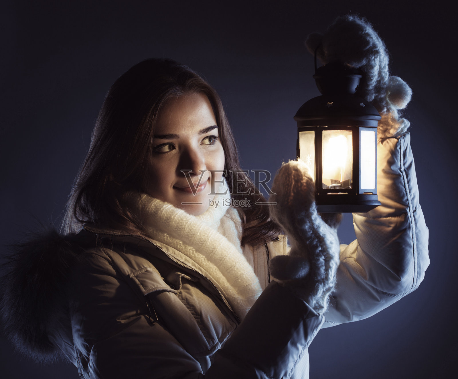 美丽的女孩在冬雪和圣诞灯笼照片摄影图片